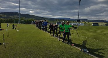 Röð af fólki í bogfimi.