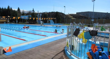 Séð yfir sundlaug, rennibraut og heitan pott í sundlauginni á Egilsstöðum.